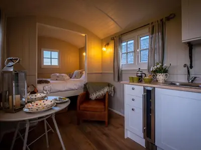 a kitchen with a table and a bed in a room at The Pleasant Hut at Mount Pleasant Farm in Ulverston