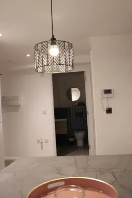 a kitchen with a table and a light hanging from a ceiling at Amazing Luxury One Bedroom Apartment in the heart of Preston in Preston