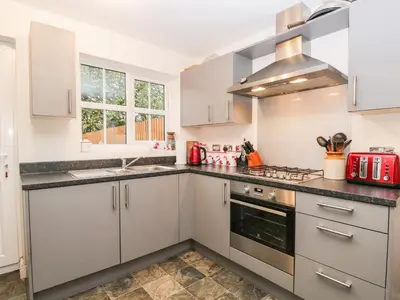 a kitchen with white cabinets and a sink at Rolo's Retreat in Grange Over Sands