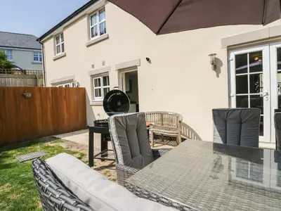 a patio with a table and chairs and a fence at Rolo's Retreat in Grange Over Sands