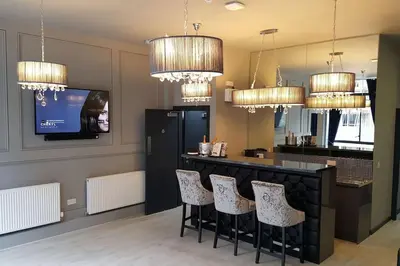 a kitchen with a bar with chairs and a tv at The V.I.P Suite - Sleeps 24! Best for large groups in Liverpool