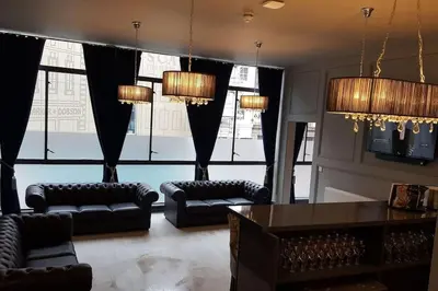 a living room with black furniture and a large window at The V.I.P Suite - Sleeps 24! Best for large groups in Liverpool