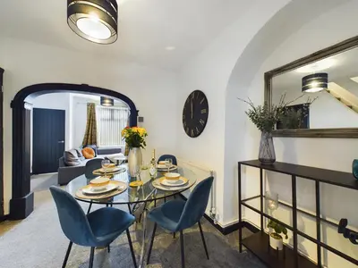 a dining room with a table and blue chairs at Charming Apartments - Cosy Retreat - short drive to city centre - Free parking in Liverpool