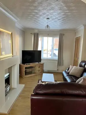 a living room with a couch and a television at Home Away in Wigan