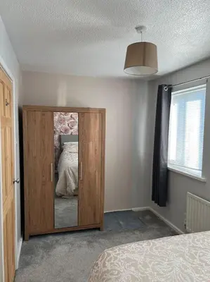 a bedroom with a door with a mirror in it at Home Away in Wigan