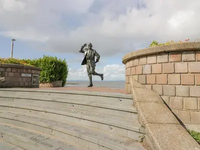 a statue of a man is standing on the stairs at The Bay Cottage - Morecambe Bay in Morecambe
