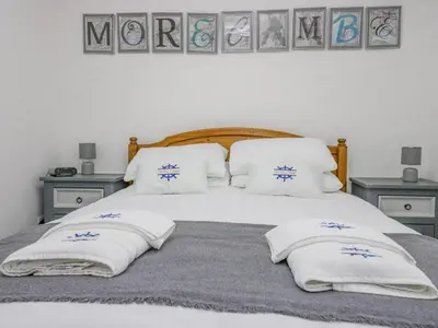 a bedroom with a bed with pillows on it at The Bay Cottage - Morecambe Bay in Morecambe