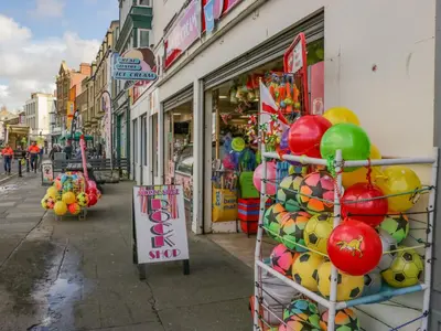 a store with a bunch of balloons on a street at The Bay Cottage - Morecambe Bay in Morecambe