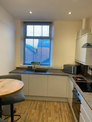 a kitchen with a sink and a table and a window at The Fort Lytham St Annes in Lytham St Annes