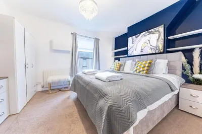 a bedroom with a large bed with a blue wall at *King Bed* Comfy City House in Barrow in Furness