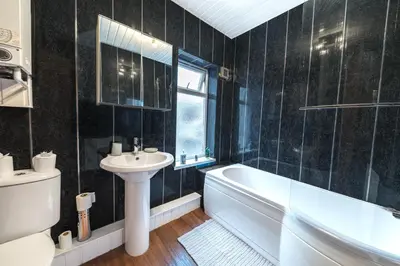 a bathroom with a sink and a tub and a toilet at *King Bed* Comfy City House in Barrow in Furness