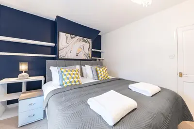 a bedroom with a large bed with blue walls at *King Bed* Comfy City House in Barrow in Furness