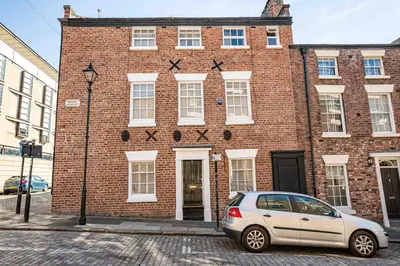 a car parked in front of a brick building at City Centre Georgian Townhouse in Liverpool