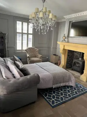 a bedroom with a bed and a fireplace and a chandelier at City Centre Georgian Townhouse in Liverpool