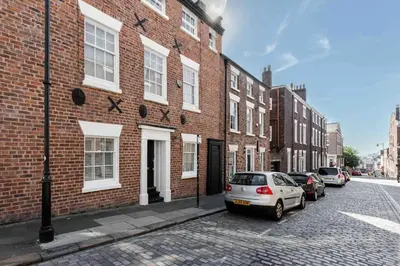 a brick building with cars parked in front of it at City Centre Georgian Townhouse in Liverpool