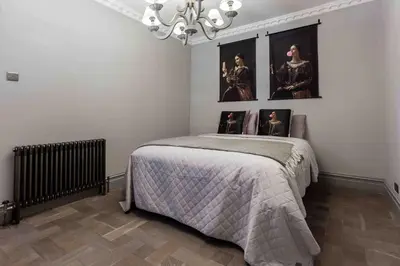 a bedroom with a bed with pictures on the wall at City Centre Georgian Townhouse in Liverpool