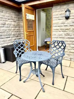 two chairs and a table on a patio at Prancing Horse Cottage in Sabden