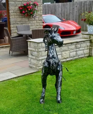 a statue of a dog standing in the grass at Prancing Horse Cottage in Sabden