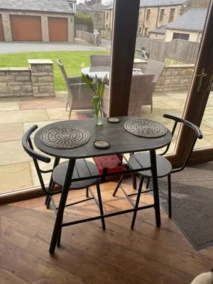 a table with two chairs and a table with a patio at Prancing Horse Cottage in Sabden