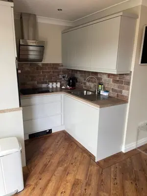 a kitchen with white cabinets and a sink at Prancing Horse Cottage in Sabden