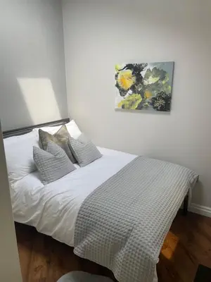 a bed in a bedroom with a painting on the wall at Prancing Horse Cottage in Sabden