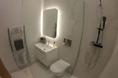 a bathroom with a toilet and a sink and a shower at Hideaway in Great Urswick