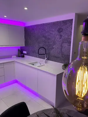 a kitchen with purple lighting and a large vase at Hideaway in Great Urswick