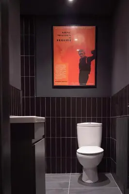 a bathroom with a toilet and a poster on the wall at Wrights Terrace - Air Host and Stay - 4 Bedroom in Liverpool