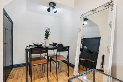 a dining room with a table and a mirror at Wrights Terrace - Air Host and Stay - 4 Bedroom in Liverpool