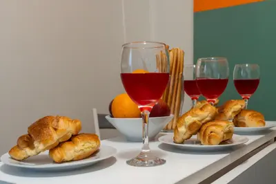 a table with three plates of food and two glasses of wine at 