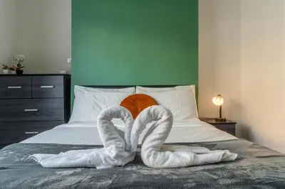 a bed with two towels shaped like swans at 