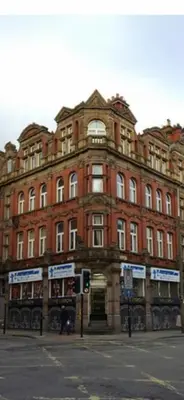 a large red brick building on the corner of a street at 2 bedroom city centre apartment 35 Victoria street in Liverpool