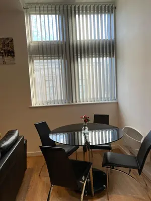 a dining room with a table and chairs and a couch at 2 bedroom city centre apartment 35 Victoria street in Liverpool