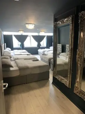a bedroom with two beds and a large mirror at City CTR DJ party apartment - ibiza suite in Liverpool