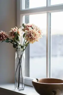 a vase with flowers in it next to a window at Smart self-catering apartment, Clitheroe in Clitheroe