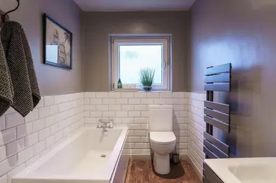 a bathroom with a tub and a toilet and a window at Smart self-catering apartment, Clitheroe in Clitheroe