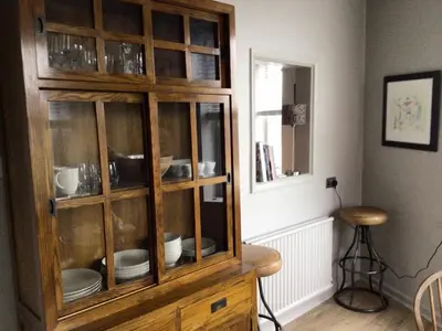 a wooden cabinet with dishes inside of it at Smart self-catering apartment, Clitheroe in Clitheroe