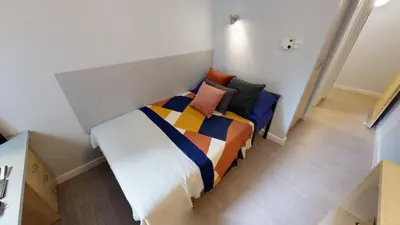 a bedroom with a bed with colorful blankets and pillows at iQ Great Newton House in Liverpool in Liverpool