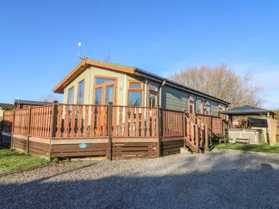 a large wooden house with a large deck at Dream Catcher Lodge in Carnforth