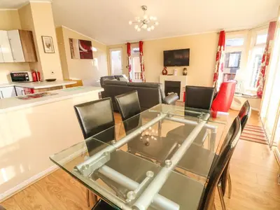 a living room with a glass table and chairs at Dream Catcher Lodge in Carnforth