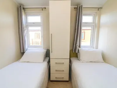 two beds in a room with two windows at Dream Catcher Lodge in Carnforth