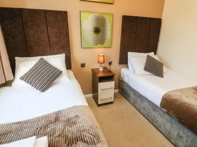 a bedroom with two beds and a night stand with a lamp at Dream Catcher Lodge in Carnforth