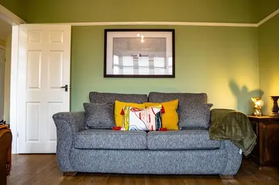 a gray couch with colorful pillows in a living room at Spacious Family Home Minutes from the Beach in Blackpool