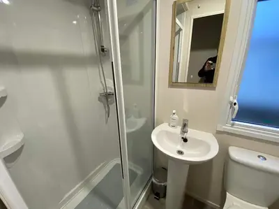 a bathroom with a shower and a sink and a toilet at A family-friendly, eight birth, 2019 Abbey Trieste Caravan in Morecambe
