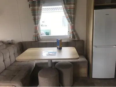 a living room with a table and a couch at A family-friendly, eight birth, 2019 Abbey Trieste Caravan in Morecambe