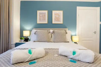 a bedroom with a large bed with blue walls at Stanley Park House - Air Host & Stay - Anfield in Liverpool