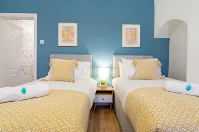 two twin beds in a room with blue walls at Stanley Park House - Air Host & Stay - Anfield in Liverpool
