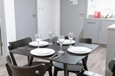 a black table with plates and wine glasses on it at Contemporary 1 Bed Apartment in Central Liverpool in Liverpool