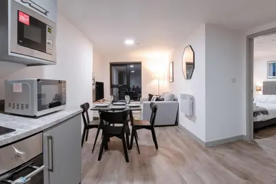 a kitchen and living room with a table and chairs at Contemporary 1 Bed Apartment in Central Liverpool in Liverpool