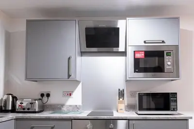 a kitchen with white cabinets and a microwave at Contemporary 1 Bed Apartment in Central Liverpool in Liverpool